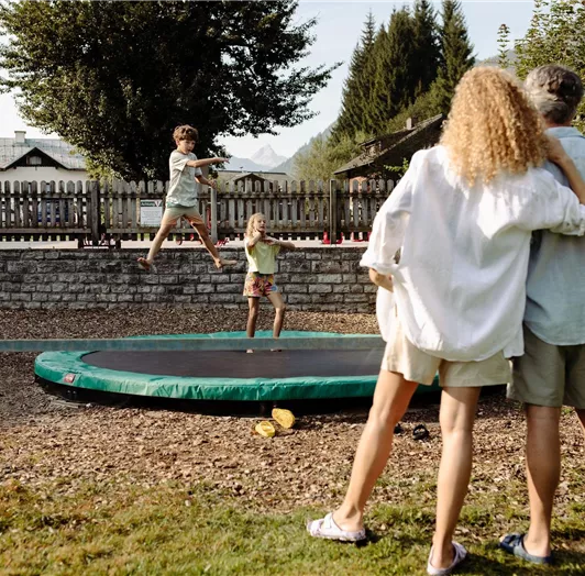 A family watches their children happily jumping on a trampoline at the Resl Resort.
