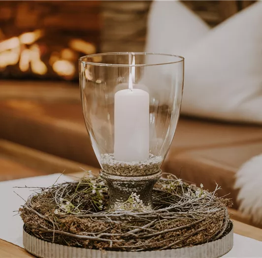 Im Hintergrund ist eine gemütliche Sitzecke mit einem Kamin sichtbar.