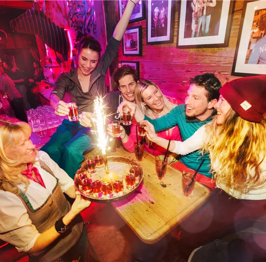 Eine Gruppe von Freunden feiert zusammen in einer Bar - Aprés Ski vom Feinsten.