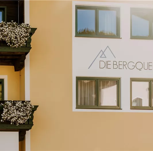 Eine helle Fassade eines Hotelgebäudes mit dem Schriftzug Hotel „DIE BERGQUELLE“.