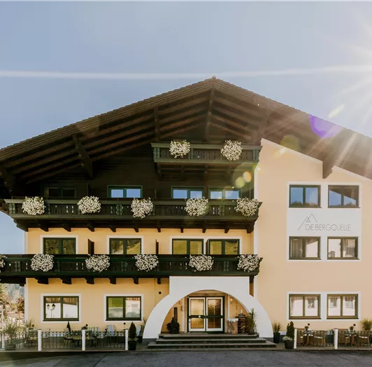 A charming hotel building with a balcony and flowers.