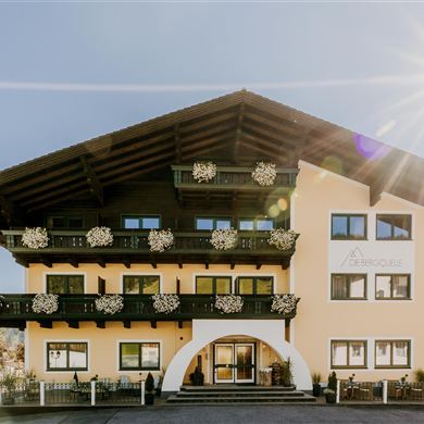 Ein charmantes Hotelgebäude mit einem Balkon und Blumen.