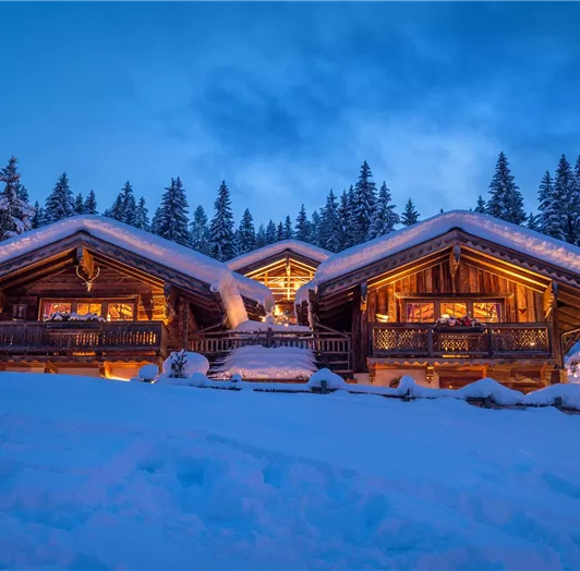 Erleben Sie Winterzauber pur – Ihr Rückzugsort in den Bergen! Willkommen in Ihrem persönlichen Wintermärchen! Unser gemütliches Almdorf erstrahlt in warmem Licht, eingebettet in eine traumhaft verschneite Landschaft. Hier erwarten Sie knisternde Kamine, liebevoll eingerichtete Chalets aus Holz und ein atemberaubender Blick auf die winterliche Natur. Lassen Sie den Alltag hinter sich – genießen Sie romantische Abende auf der Hüttenterrasse, entspannte Stunden in der Sauna oder gemeinsame Momente 
