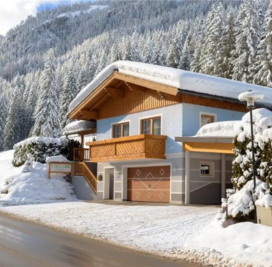 A cozy house in the snow, surrounded by snow-covered fir trees. The landscape features gentle hills and a quiet road.