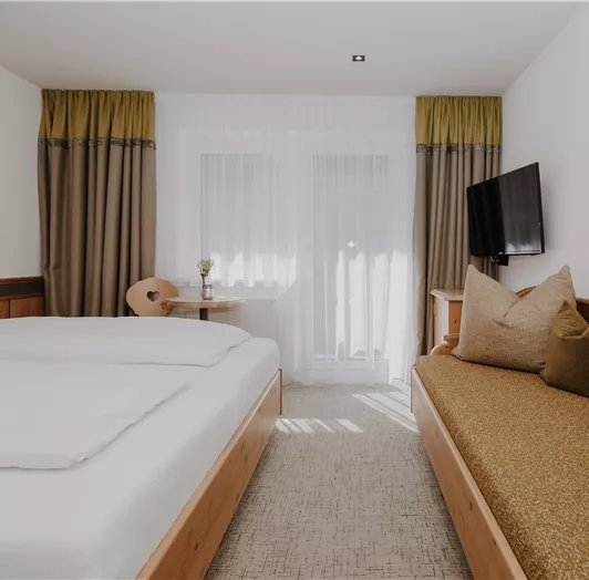 Ein modernes Doppelzimmer Comfort mit zwei Betten und einem gemütlichen Sofa.