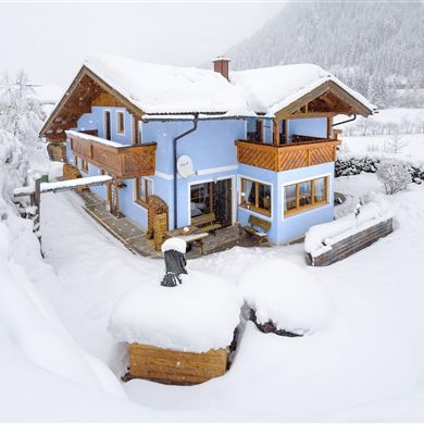A charming house in a snowy landscape. The snow covers the surroundings and creates a cozy winter atmosphere.