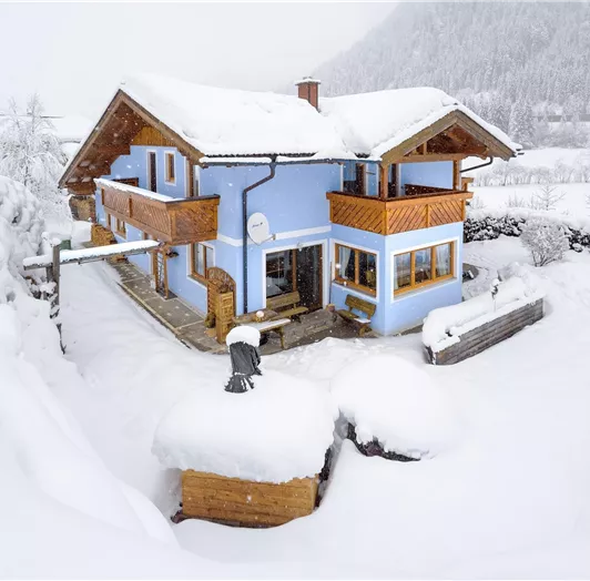 A charming house in a snowy landscape. The snow covers the surroundings and creates a cozy winter atmosphere.