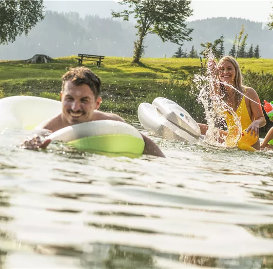 Eine Gruppe von Menschen hat Spaß im Wasser, während sie auf Schwimmreifen fahren.