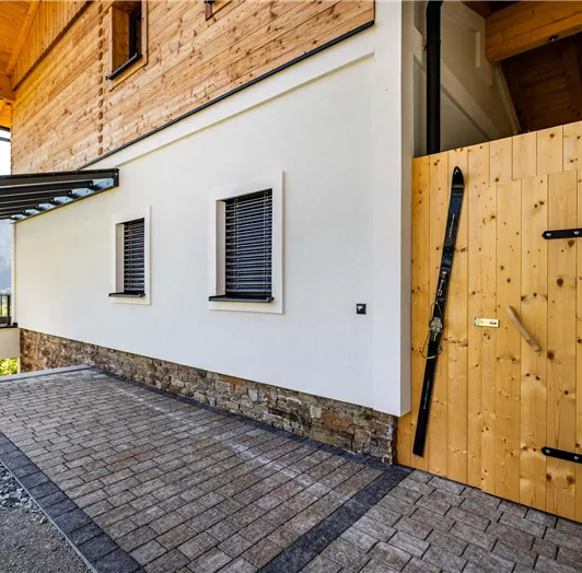 Der Eingangsbereich zum Appartement TYP A. Hinter der Holztür befindet sich der Skiraum im Winter, im Sommer kann man die Fahrräder auch darin abstellen.