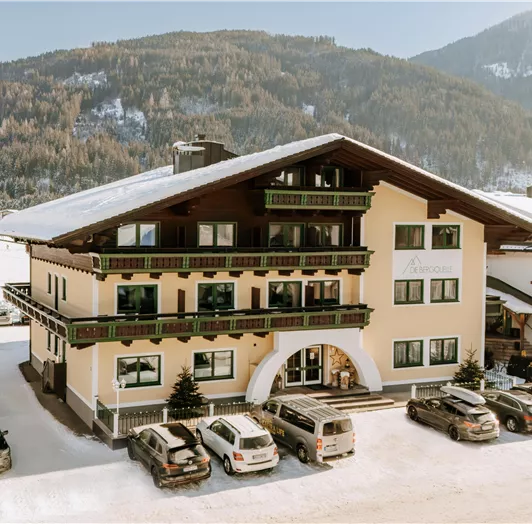 Ein charmantes Hotel im schneebedeckten Gelände mit Bergblick.