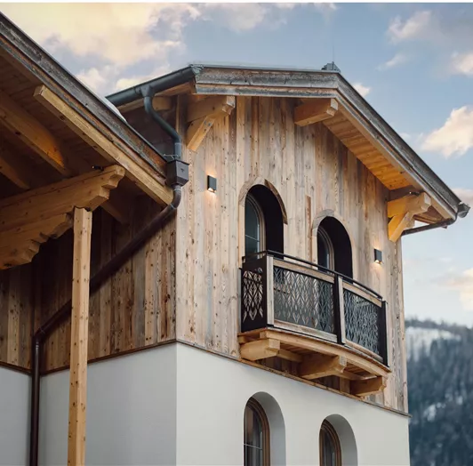 Tradition meets modernity at the Bed & Breakfast Hotel Lisa with wooden cladding and balconies. The surroundings are mountainous and picturesque.
