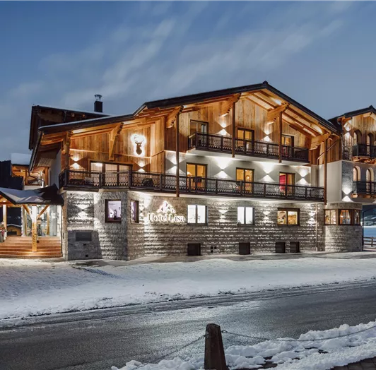 Hotel Lisa in Flachau in the Salzburg mountains, illuminated at night, snow-covered in winter.