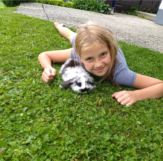 Unsere Tochter Sarah, gemütlich im grünen Gras mit einem Hasenbaby