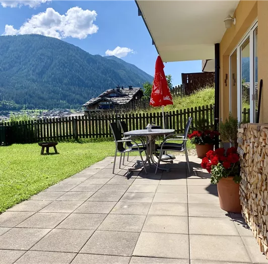 Sonnige Terrasse mit eingezäuntem Garten und Panoramablick. Genießen Sie entspannte Stunden auf der großzügigen, sonnigen Terrasse mit direktem Zugang zum vollständig eingezäunten Garten – ideal für Hundebesitzer. Umgeben von blühenden Blumen, komfortablen Gartenmöbeln und einem herrlichen Ausblick auf die umliegende Bergwelt bietet dieser Außenbereich den perfekten Ort zum Verweilen und Entschleunigen. Der gepflegte Rasen lädt zum Spielen, Sonnenbaden oder einfach zum Durchatmen ein – inmitten 