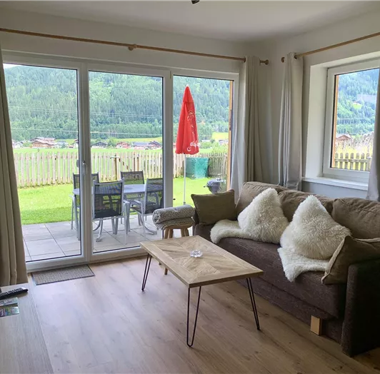 Naturkino direkt vor der Tür. Große Fensterfronten und direkter Zugang zur Terrasse eröffnen einen traumhaften Panoramablick auf die umliegende Bergwelt. Vom gemütlichen Wohnbereich aus schweift der Blick über grüne Wiesen und Wälder – ein Anblick, der zu jeder Jahreszeit begeistert. Die Kombination aus hochwertigem Interieur und beeindruckender Aussicht macht dieses Appartement zum Rückzugsort mit echter Wohlfühlgarantie.