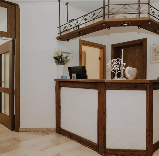 Ein Empfangsbereich mit einer Holztheke und einer modernen Einrichtung.