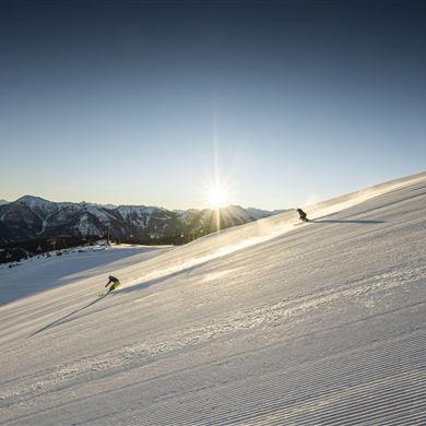 First departure at 8:00 AM in Snow Space Salzburg. In the background, the sun shines over the mountains.