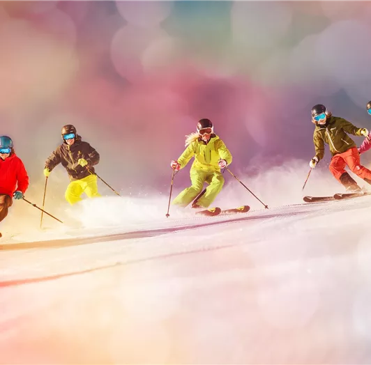 Eine Gruppe von fünf Skifahrern fährt den Hang hinunter.