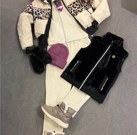 Eine modische Winterausstattung mit einer Jacke, einer Weste, einer Hose und Sneakers. Die Stücke sind in neutralen Farben gehalten und kombinieren Komfort mit Stil.