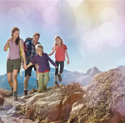 Eine Familie wandert auf einem Bergweg.