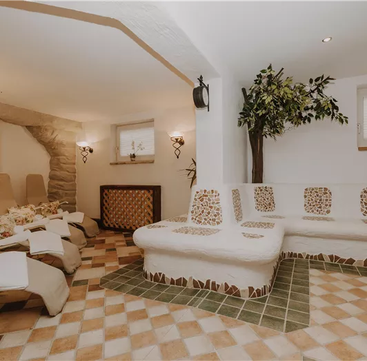 Ein gemütlicher Wellnessbereich mit komfortablen Liegen und einer entspannten Atmosphäre.